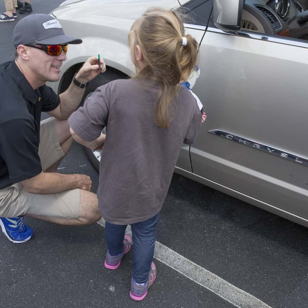 Racing toward Memorial Day Weekend, the unofficial start of the summer driving season, the Goodyear Tire & Rubber Company and NASCAR champion Kevin Harvick (seen here teaching a young fan about tire maintenance), provided free tire checks to consumers at the Concord Mills Mall in Concord, NC to help prepare them leading into National Tire Safety Week. (Jason E. Miczek/AP Images for Goodyear)